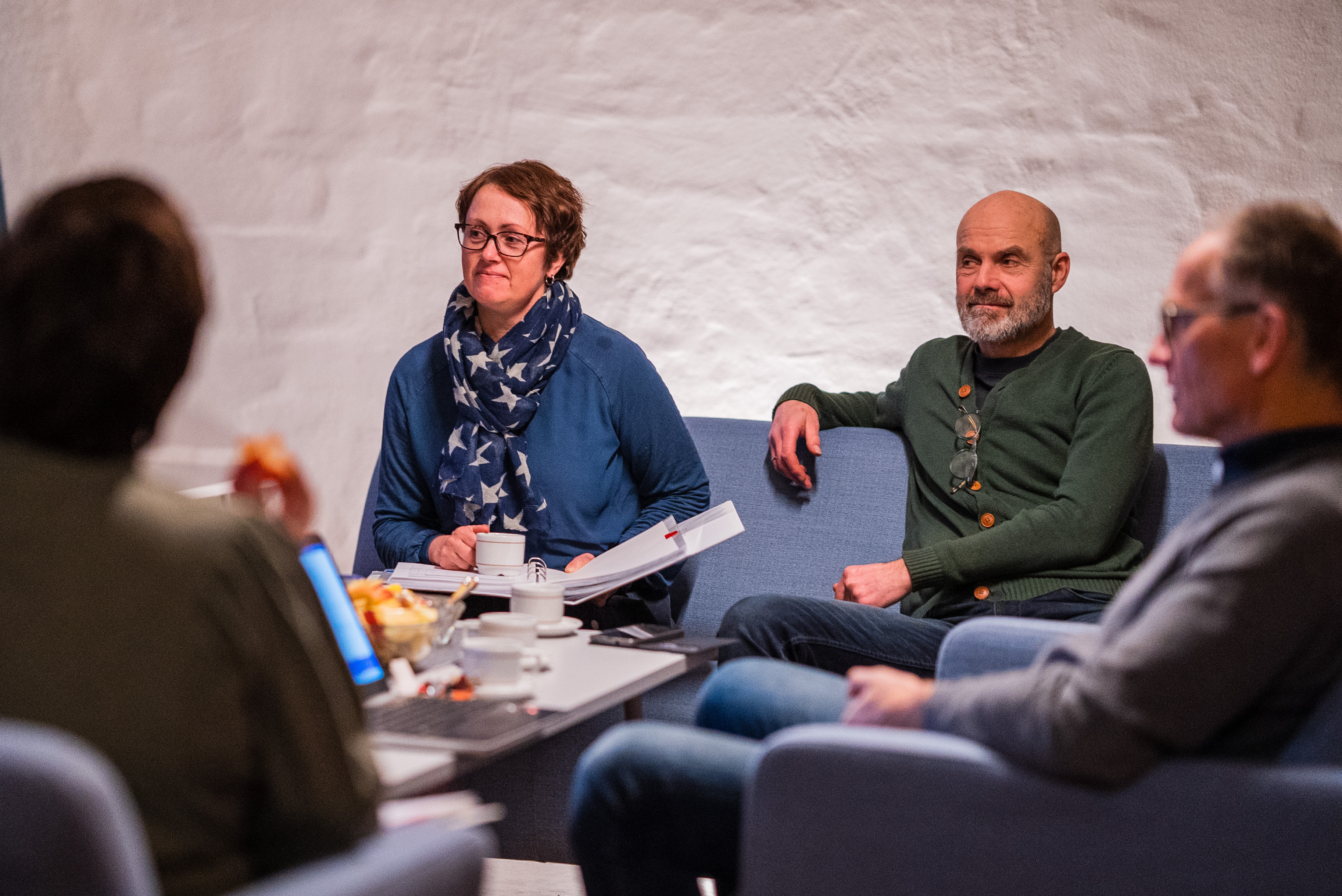 Fire voksne sitter rundt et bord